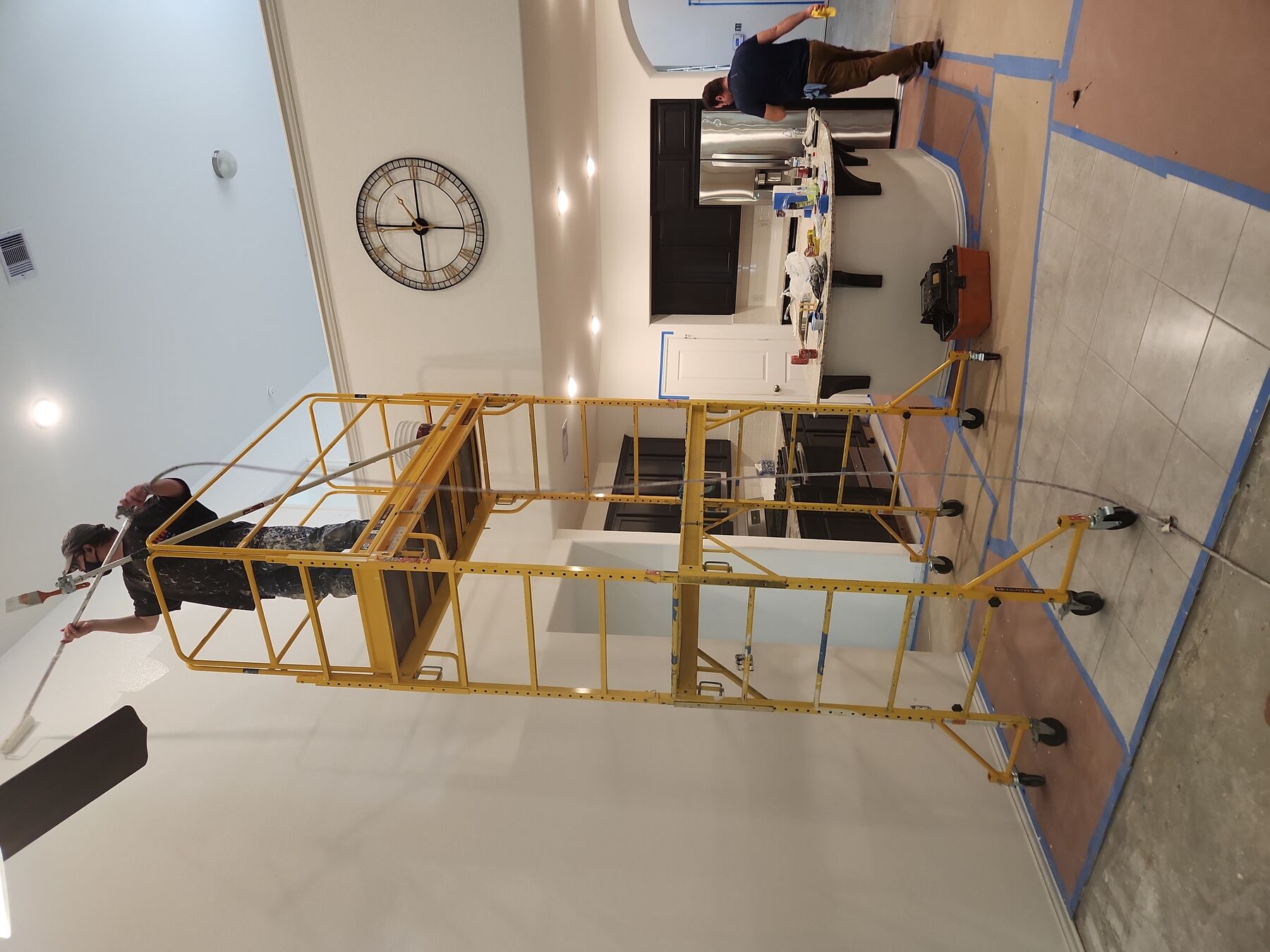 HRH Repairs team painting an elevated interior wall